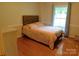 Warm bedroom with hardwood floors, featuring a bed with a wooden headboard, dresser, and natural light at 714 Shady Dr, Albemarle, NC 28001