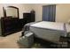 Cozy bedroom featuring dark wood furniture, patterned bedding, and a set of pet stairs for easy access at 714 Shady Dr, Albemarle, NC 28001