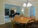 Dining area with a wood table, chairs, and an open view into the cozy living room at 714 Shady Dr, Albemarle, NC 28001