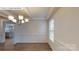 Formal dining room with wood floors, wainscoting, view to kitchen, and a chandelier at 7172 Sylvan Retreat Dr, Denver, NC 28037