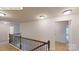 Upstairs hallway with wood railing, carpet floor, and bright lighting from flush mount ceiling lights at 7172 Sylvan Retreat Dr, Denver, NC 28037