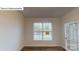 Bright room showcasing hardwood floors, paneled walls, a large window and a glass paneled door at 7190 Sylvan Retreat Dr, Denver, NC 28037