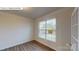 Bright room showcasing hardwood floors, paneled walls, a large window and a glass paneled door at 7190 Sylvan Retreat Dr, Denver, NC 28037