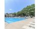 Large community pool surrounded by lounge chairs and lush green trees on a sunny day at 8350 Brickle Ln, Huntersville, NC 28078