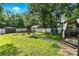 Spacious backyard with mature trees, featuring a shed, playset, trampoline, and cozy pergola-covered seating area at 840 10Th Street Nw Blvd, Hickory, NC 28601