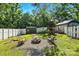 The backyard features a playset, a shed, and a brick firepit with chairs, all surrounded by green grass and a white fence at 840 10Th Street Nw Blvd, Hickory, NC 28601