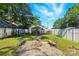 Backyard featuring a fire pit with chairs and benches on a lush green lawn enclosed with white fencing at 840 10Th Street Nw Blvd, Hickory, NC 28601