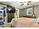 Well-lit bedroom with ceiling fan, TV, window, and access to laundry area and bathroom at 840 10Th Street Nw Blvd, Hickory, NC 28601