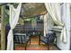 The backyard porch is set with seating, a rug, and macrame wall art, providing a cozy outdoor living space at 840 10Th Street Nw Blvd, Hickory, NC 28601