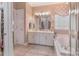 Bathroom with double vanity, soaking tub, and decorative fixtures at 9040 Scottsboro Dr, Huntersville, NC 28078