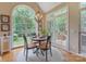 Sunlit dining area with a modern chandelier and multiple windows overlooking the backyard at 9040 Scottsboro Dr, Huntersville, NC 28078