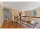 Upstairs hallway with hardwood floors, and a comfortable chair and desk space overlooking foyer at 9040 Scottsboro Dr, Huntersville, NC 28078