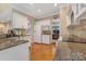Well-designed kitchen featuring granite countertops, white cabinets, hardwood floors, and a functional layout at 9040 Scottsboro Dr, Huntersville, NC 28078