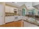 Bright kitchen with white cabinets, granite countertops, stainless steel appliances, and a large arched window above the sink at 9040 Scottsboro Dr, Huntersville, NC 28078