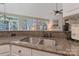 A kitchen sink and granite countertops are complimented by a window view in this home at 9040 Scottsboro Dr, Huntersville, NC 28078