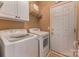 Efficient laundry room with washer, dryer, shelving, and easy access to the outside at 9040 Scottsboro Dr, Huntersville, NC 28078
