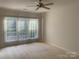 Bright bedroom features large windows, neutral walls, ceiling fan, and plush carpeting at 919 Lily Magnolia Ct, Fort Mill, SC 29707