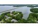 Aerial view of complex surrounded by trees and lake with bridge in the background at 921 Northeast Dr, Davidson, NC 28036