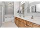 Bright bathroom featuring double sink vanity with a separate tub and neutral tile flooring at 921 Northeast Dr, Davidson, NC 28036