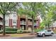 Brick condo building featuring patios, manicured landscaping, and covered garage entrance at 921 Northeast Dr, Davidson, NC 28036