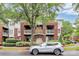 Brick condo building featuring patios, manicured landscaping, and covered garage entrance at 921 Northeast Dr, Davidson, NC 28036