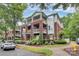 Exterior view of condo building with brick facade, covered patios and verdant, manicured landscaping at 921 Northeast Dr, Davidson, NC 28036