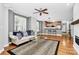 Open-concept living room with hardwood floors, fireplace, ceiling fan, and adjacent kitchen at 921 Northeast Dr, Davidson, NC 28036