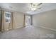 A carpeted bedroom with neutral walls, a ceiling fan, and a glass patio door at 10078 Pergola View Ct, Charlotte, NC 28213