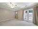 A carpeted bedroom with neutral walls, a ceiling fan, and a glass patio door at 10078 Pergola View Ct, Charlotte, NC 28213