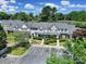 Aerial view of gray townhomes with black shutters and a parking lot in front at 10078 Pergola View Ct, Charlotte, NC 28213