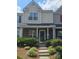 Inviting townhome with brick and vinyl siding, a covered porch, and well-maintained front yard landscaping at 10078 Pergola View Ct, Charlotte, NC 28213