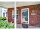 Close-up of brick porch, door, and window with view of street; shows home's address at 10078 Pergola View Ct, Charlotte, NC 28213