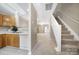 Hallway provides views of the staircase, kitchen, and living room, with neutral decor throughout at 10078 Pergola View Ct, Charlotte, NC 28213