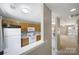 Kitchen with white appliances and wooden cabinets is connected to the living room and entry way at 10078 Pergola View Ct, Charlotte, NC 28213