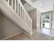 This staircase has carpeted stairs, a white banister, and a front door with glass at 10078 Pergola View Ct, Charlotte, NC 28213