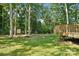 Expansive backyard with mature trees and a wooden deck, offering privacy and outdoor enjoyment at 116 Scottie Ct, Rock Hill, SC 29730