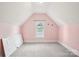 Cozy pink bedroom featuring an attic window and neutral carpet at 116 Scottie Ct, Rock Hill, SC 29730