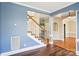 A view of the foyer features an open stairway with wooden handrail, and hardwood floors at 116 Scottie Ct, Rock Hill, SC 29730