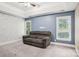 Blue accent wall living room features gray sofa, carpet, and double hung windows at 116 Scottie Ct, Rock Hill, SC 29730