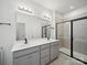 Modern bathroom featuring a double vanity, large mirror, and glass enclosed shower with tile surround at 1207 Laggan Ln, Indian Trail, NC 28079