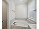 Bathroom featuring a soaking tub with tiled surround and sleek, matte black fixtures at 1207 Laggan Ln, Indian Trail, NC 28079