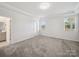 Bright main bedroom featuring tray ceilings, neutral carpet, two windows with beautiful views at 1207 Laggan Ln, Indian Trail, NC 28079