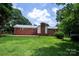 Expansive backyard with brick accents and lush lawn, ideal for relaxation and recreation at 1216 Manchester Ln, Charlotte, NC 28227