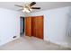 A comfortable bedroom features a fan, closet space, and neutral carpeting at 1216 Manchester Ln, Charlotte, NC 28227