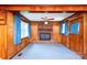 Living area showcasing wood paneling, a classic brick fireplace, blue carpet, and bright windows at 1216 Manchester Ln, Charlotte, NC 28227