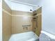 Cozy bathroom with tiled walls and a bathtub and shower combination with grab bars and accessible features at 1227 Flowe Dr, Matthews, NC 28104