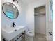 Stylish bathroom showcasing a round mirror, sleek sink, and modern fixtures with an adjacent closet at 1227 Flowe Dr, Matthews, NC 28104