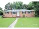 Charming brick home with a well-maintained front yard, showcasing curb appeal and a welcoming entrance at 1227 Flowe Dr, Matthews, NC 28104