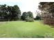 Spacious front yard with lush green grass and mature trees, enhancing the home's curb appeal and outdoor space at 1227 Flowe Dr, Matthews, NC 28104
