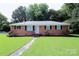 Charming brick home featuring a well-manicured lawn and inviting walkway at 1227 Flowe Dr, Matthews, NC 28104